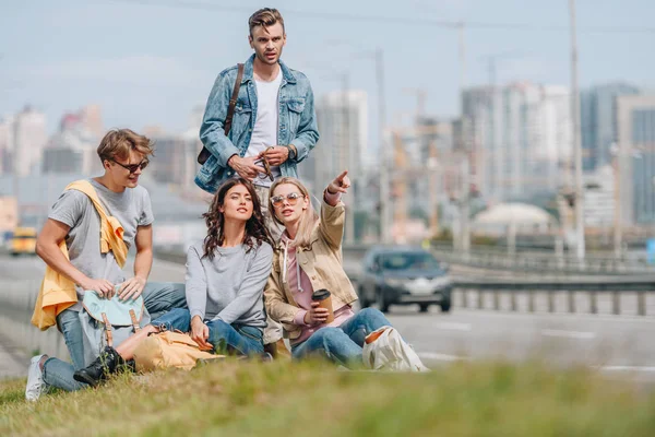 Group of young travelers with backpacks in new city — Stock Photo