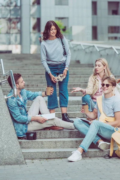 Young tourists resting on street steps in new city — Stock Photo