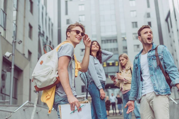 Grupo de jovens turistas com mochilas em pé na rua em nova cidade — Fotografia de Stock