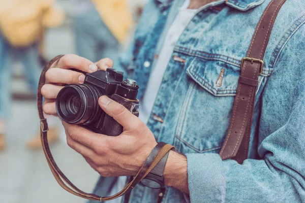 Обрезанный снимок туриста с фотокамерой в руках — стоковое фото