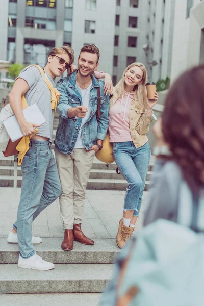 Photographer taking photo of hugging friends in city — Stock Photo