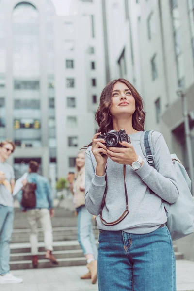 Attraente ragazza con macchina fotografica a piedi in città urbana con gli amici — Foto stock