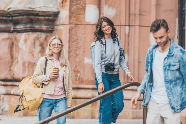 Молодые друзья с рюкзаками проводят время вместе в городе — стоковое фото