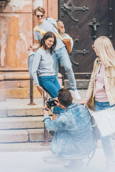 Hombre tomando fotos de amigos felices en la cámara - foto de stock