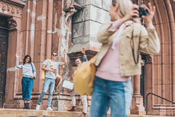 Вибірковий фокус друзів махають до дівчини фотографуючи місто на камеру — стокове фото