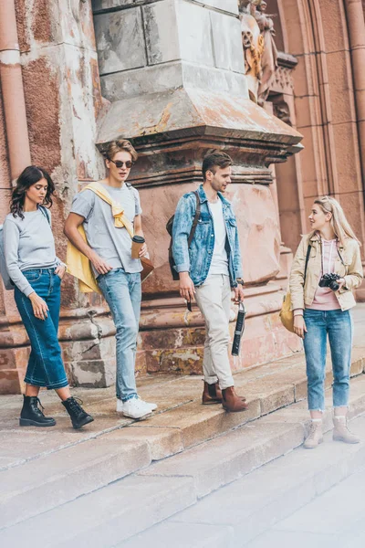 Jeunes touristes élégants marchant dans la ville ensemble — Photo de stock
