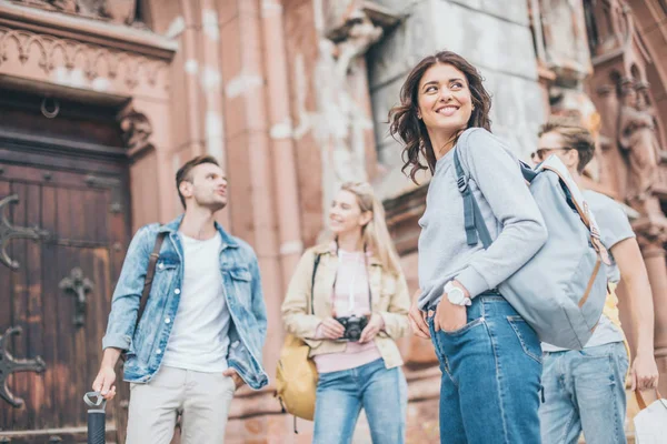 Jóvenes turistas sonrientes pasando tiempo juntos en la ciudad - foto de stock