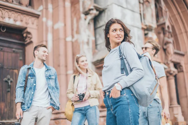 Young happy stylish friends walking in city — Stock Photo