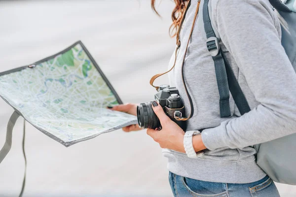 Vista recortada del viajero sosteniendo la cámara fotográfica y el mapa en la ciudad - foto de stock