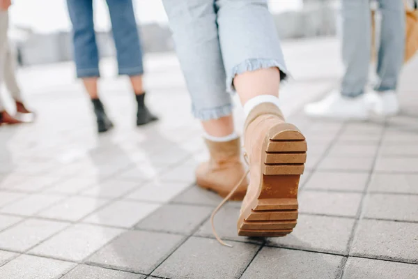 Visão de seção baixa de mulher andando na rua com amigos — Fotografia de Stock