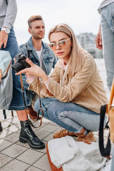 Приваблива жінка-фотограф з камерою в місті з туристами — стокове фото