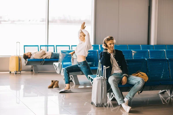 Jovem atraente praticando ioga enquanto espera voo no terminal do aeroporto — Fotografia de Stock