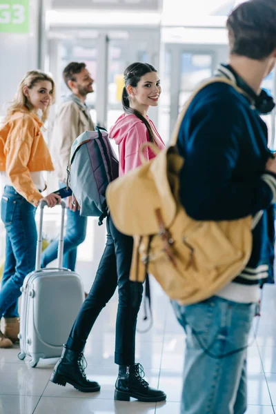 Jovens felizes com bagagem no terminal do aeroporto — Fotografia de Stock