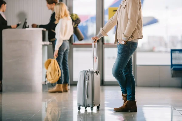 Plan recadré d'un homme avec une valise près du comptoir d'enregistrement à l'aéroport — Photo de stock