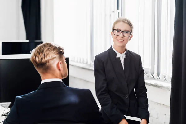 Young businessman and businesswoman in formal wear working together in open space office — Stock Photo