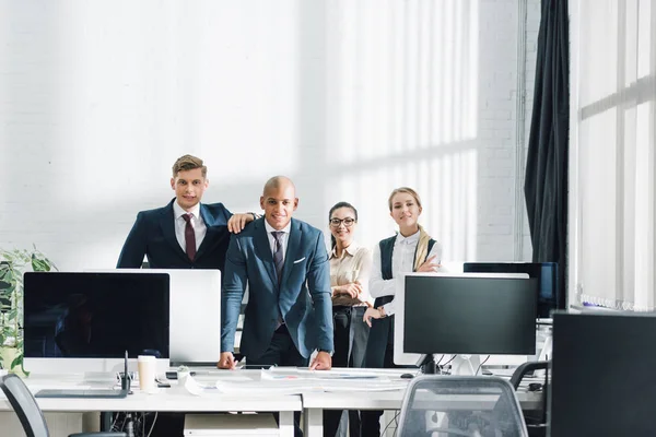 Professionelles junges multiethnisches Business-Team lächelt im Großraumbüro in die Kamera — Stockfoto