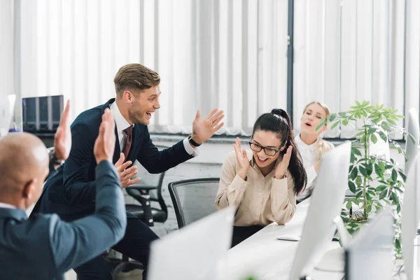 Entusiasmados jóvenes colegas de negocios celebrando buenas noticias en el cargo — Stock Photo