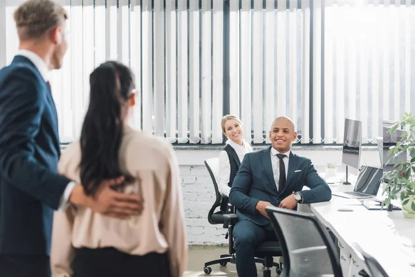 Visão retrospectiva do empresário introduzindo novo colega para jovens empresários sorridentes no cargo — Fotografia de Stock