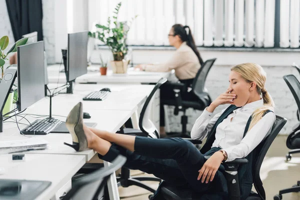 High angle view of young woman yawning at workplace — Stock Photo