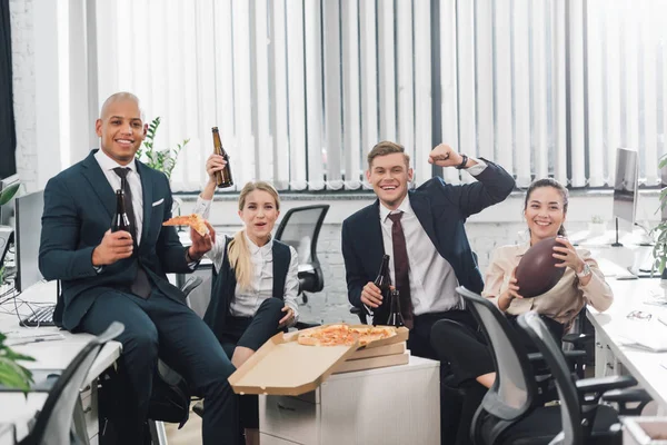 Animados jovens empresários bebendo cerveja e comendo pizza no escritório — Fotografia de Stock