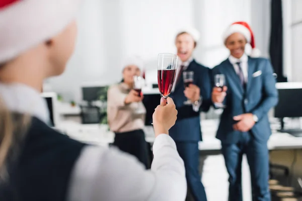 Enfoque selectivo de los jóvenes compañeros de trabajo beber vino y celebrar el año nuevo en el cargo - foto de stock