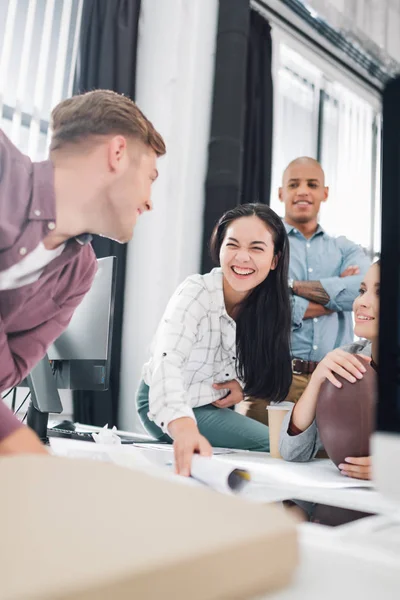 Happy young business people laughing while working together in office — Stock Photo