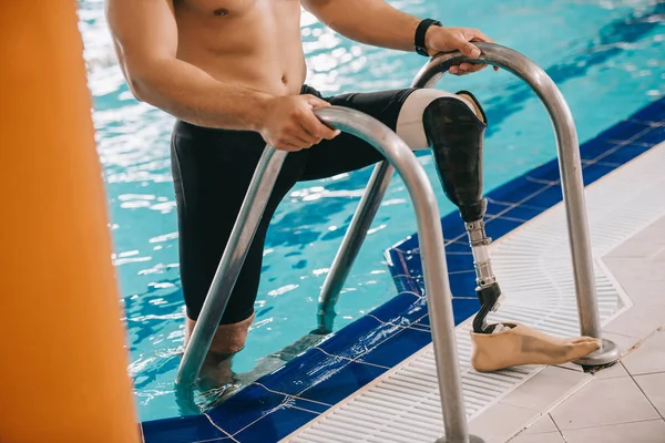 Обрізаний знімок спортивного плавця зі штучною ногою, що виходить з басейну — стокове фото
