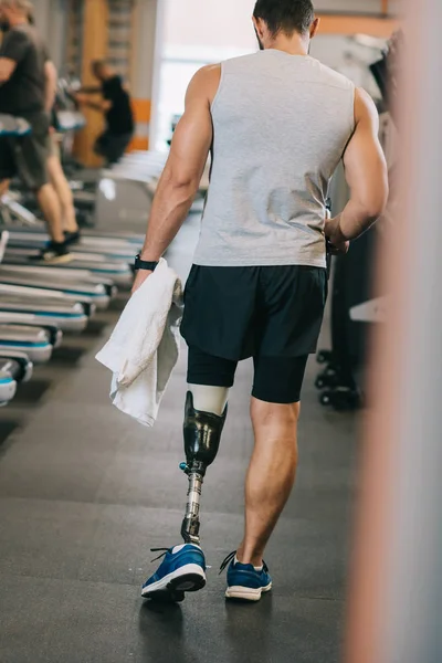 Vista trasera del deportista con pierna artificial caminando por el gimnasio - foto de stock