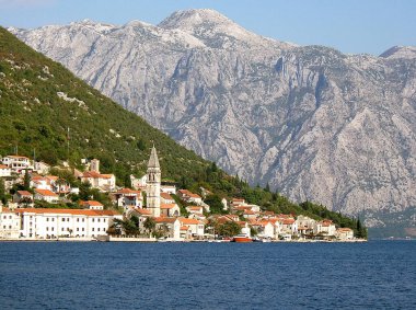 Perast kasabası ve çan kulesinin bir kısmı Karadağ 'ın turistik motorlu teknesinden Kotor Körfezi boyunca görülüyor
