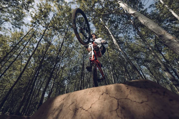 Bottom view of extreme sportsman jumping with mountain bike — Stock Photo