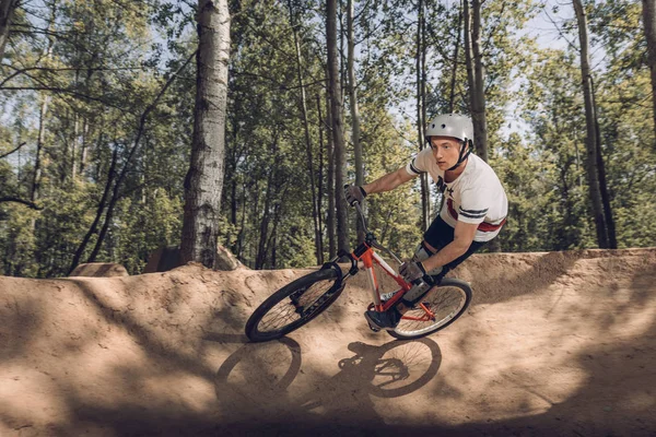 Cyclist riding mountain bike on track in forest — Stock Photo