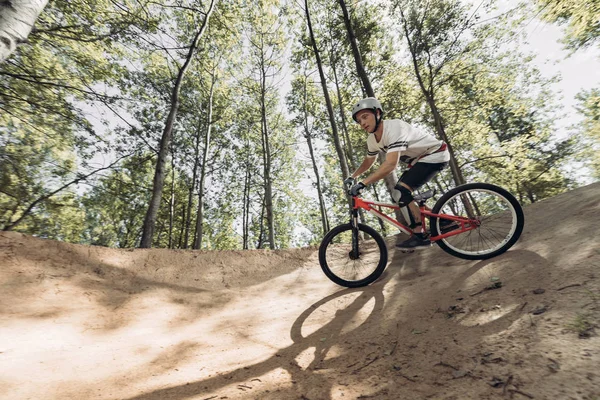 Racer riding mountain bike on track in forest — Stock Photo
