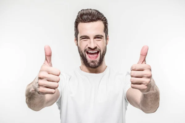 Happy young man showing thumbs up isolated on white — Stock Photo
