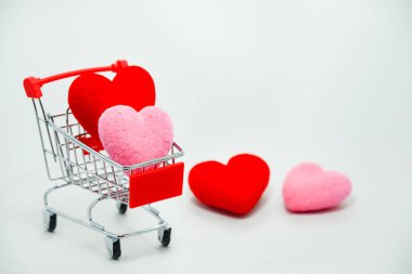 Mini alışveriş arabası zemin üzerine düşen Sevgililer günü için kırmızı ve pembe kalpler. En iyi görünüm ve kopya alanı.