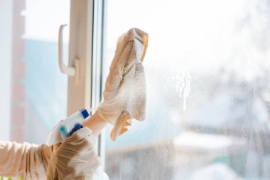 Kadın bir pencere yıkar. Genç kadın bir pencere kir temizler. Evin içinde saf windows.