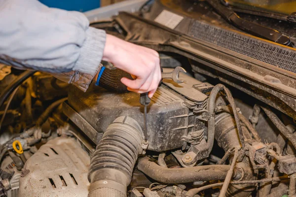 The man repairs the car. Maintenance of the car.