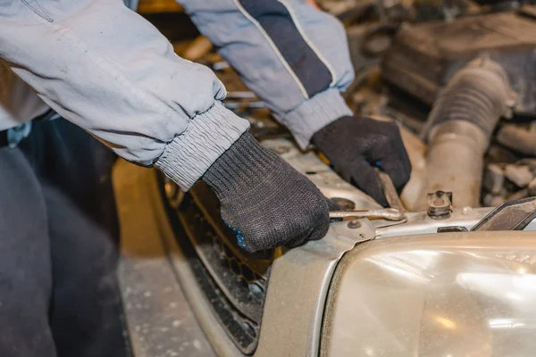 The man repairs the car. Maintenance of the car.