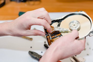 Adam bir sabit disk onarır. Kopyyuterny teknik tamiri için servis.