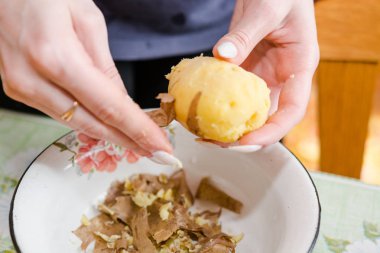 Kadın sebze salataya keser. Kesikler patates, pancar, havuç.