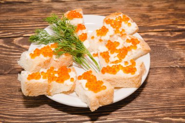 Kırmızı havyar. Havyar ekmek ve tereyağı parçası üzerinde. Petrol bir tablo ile bir incelik havyar. Gurmeler için gıda