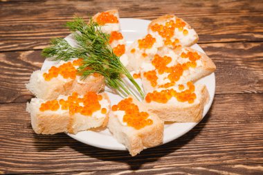 Kırmızı havyar. Havyar ekmek ve tereyağı parçası üzerinde. Petrol bir tablo ile bir incelik havyar. Gurmeler için gıda