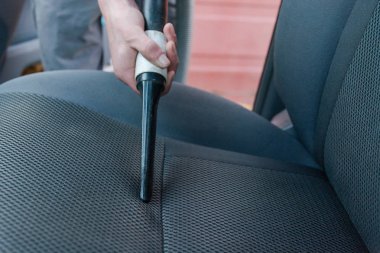 Adam vacuums bir yolcu bölmesi içinde. Genç adam gelgit arabayı yukarı.