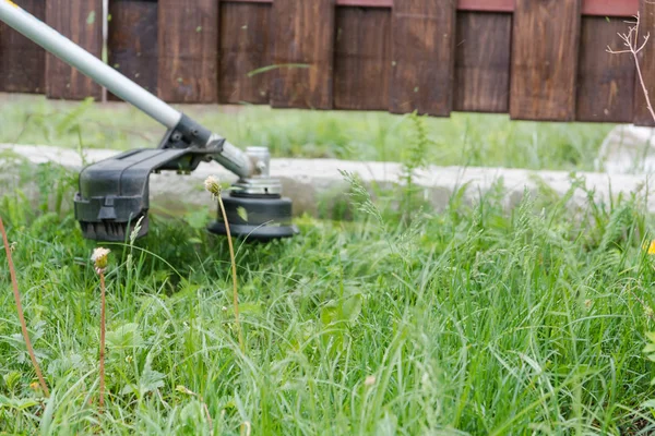 to cut a grass. Strich grass mower. To cut a lawn. The man cuts a lawn.