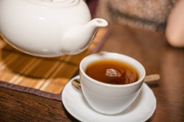 Siyah çay beyaz bir çaydanlık bir kafeden bir kupa dökmek