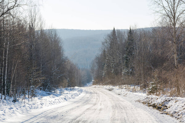 Зимняя дорога в лесу. Дорога в Сибири зимой. Тайга-дорога в России.