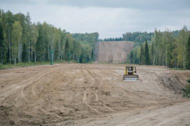 Ormanda, traktör kil yolunu hizalar.