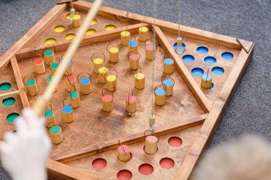 Çocuk oyunları ile renkli şekiller. Ahşap bir şekil üzerinde yem yakalamak. Rakamlar yerlerde yerleştirin. Çocuklar için oyunlar eğitim