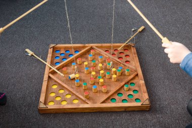 Çocuk oyunları ile renkli şekiller. Ahşap bir şekil üzerinde yem yakalamak. Rakamlar yerlerde yerleştirin. Çocuklar için oyunlar eğitim