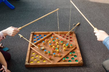 Çocuk oyunları ile renkli şekiller. Ahşap bir şekil üzerinde yem yakalamak. Rakamlar yerlerde yerleştirin. Çocuklar için oyunlar eğitim