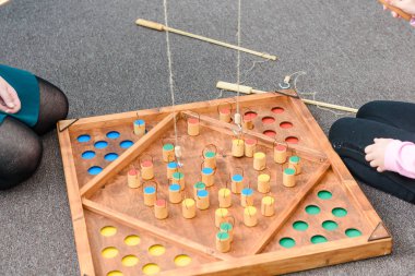 Çocuk oyunları ile renkli şekiller. Ahşap bir şekil üzerinde yem yakalamak. Rakamlar yerlerde yerleştirin. Çocuklar için oyunlar eğitim